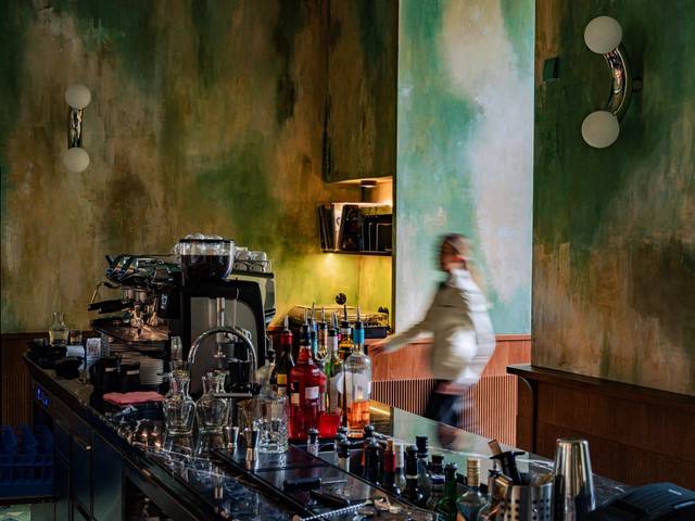 Ein Restaurant mit gelben Sitzgelegenheiten und eleganten Kronleuchtern.