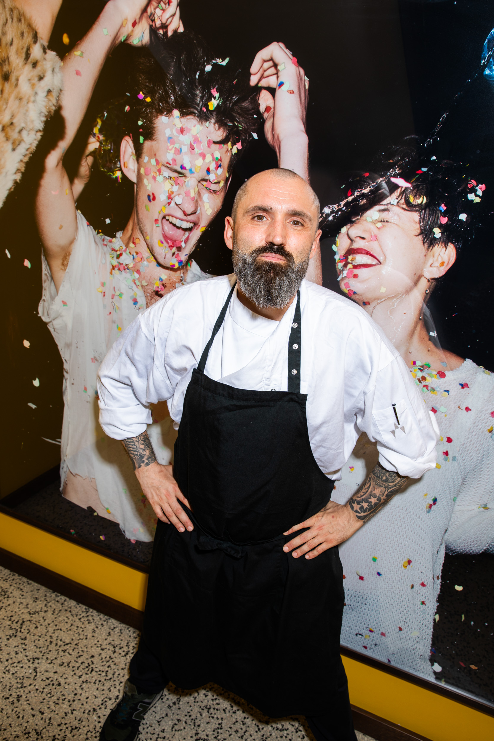 Küchenchef Florian Oswald vor einem Foto von Wolfgang Zac im Stiegenhaus im The Guesthouse Vienna.