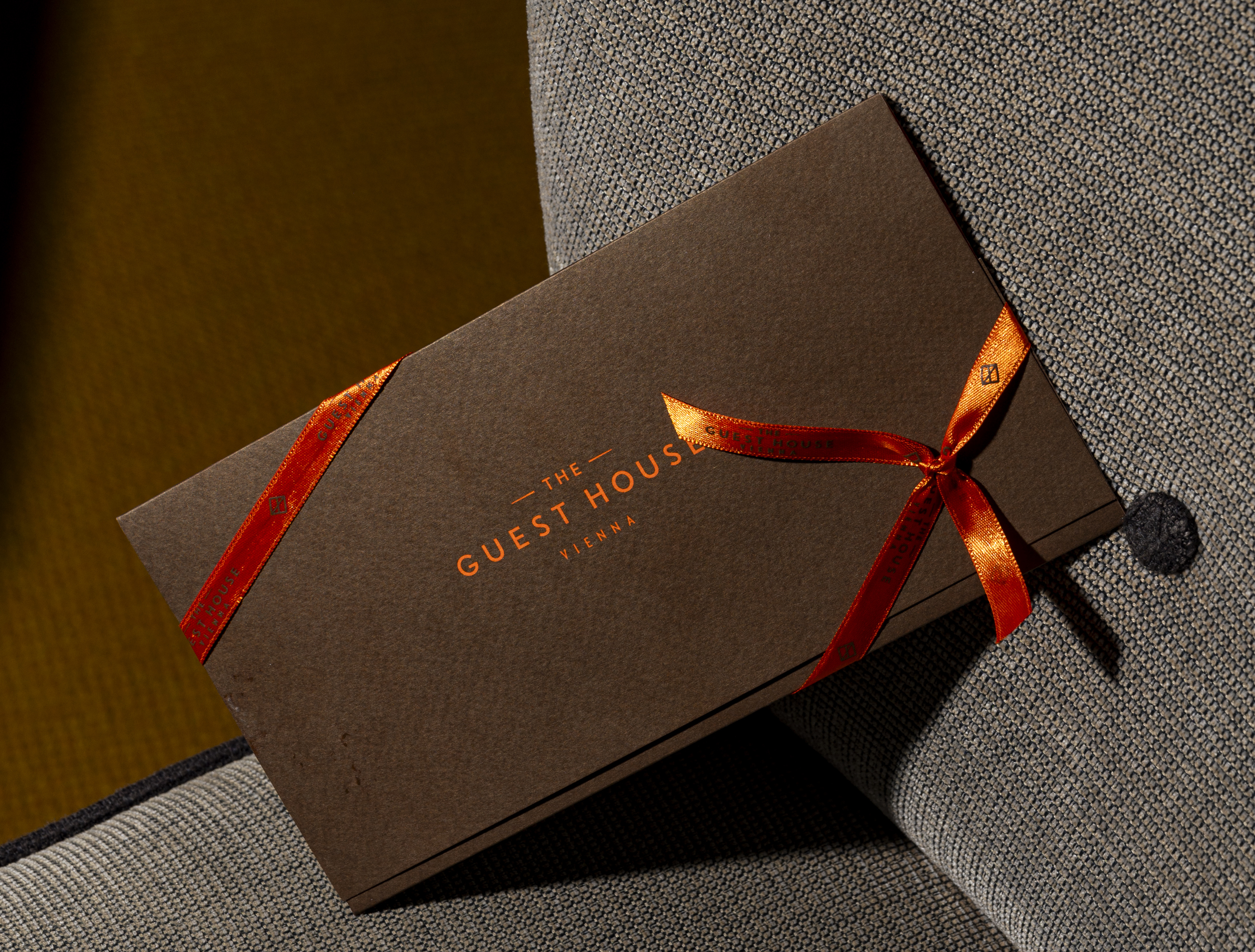Eine braune Geschenkkarte mit rotem Band.